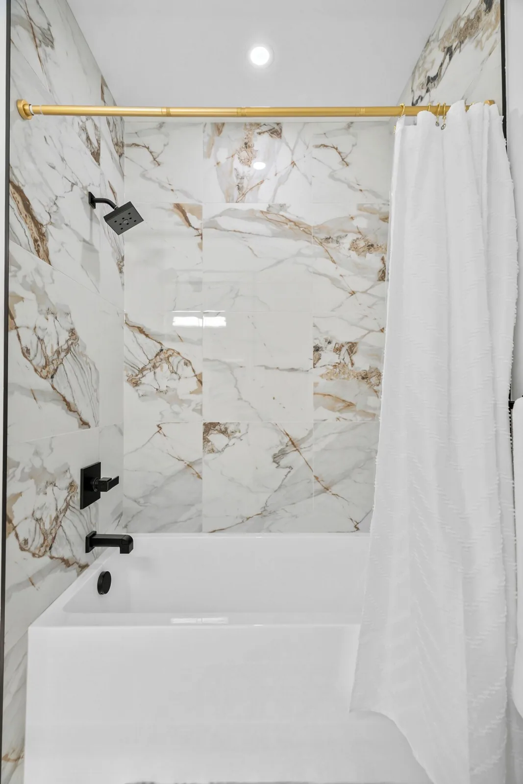 Marble tiled tub and shower cleaned during a turnover